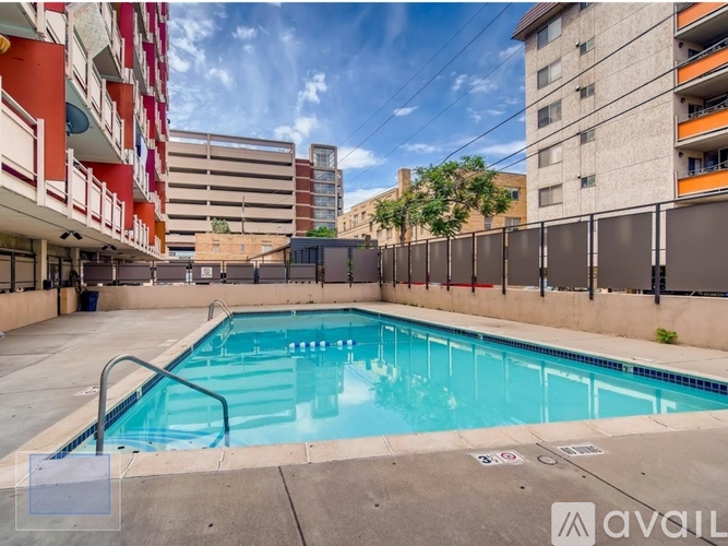 A pool surrounded by buildings and a fence.