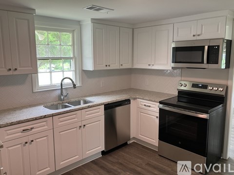 A kitchen with white cabinets and a black oven.