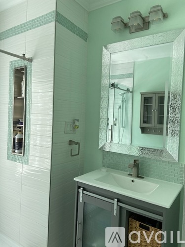 A bathroom with a white sink and a mirror above it.