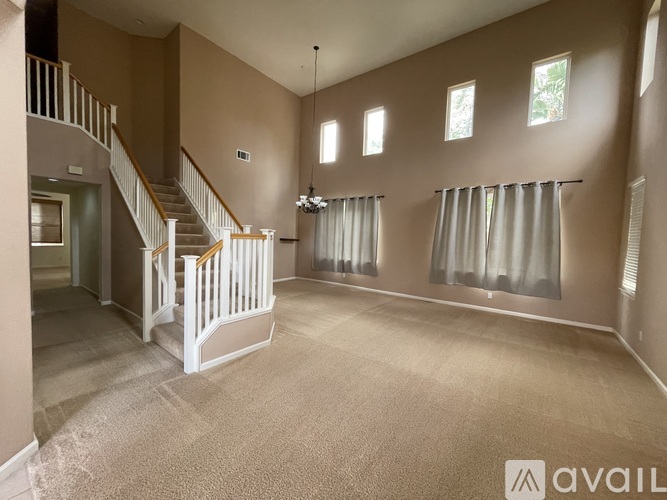 A spacious room with a staircase and a window.