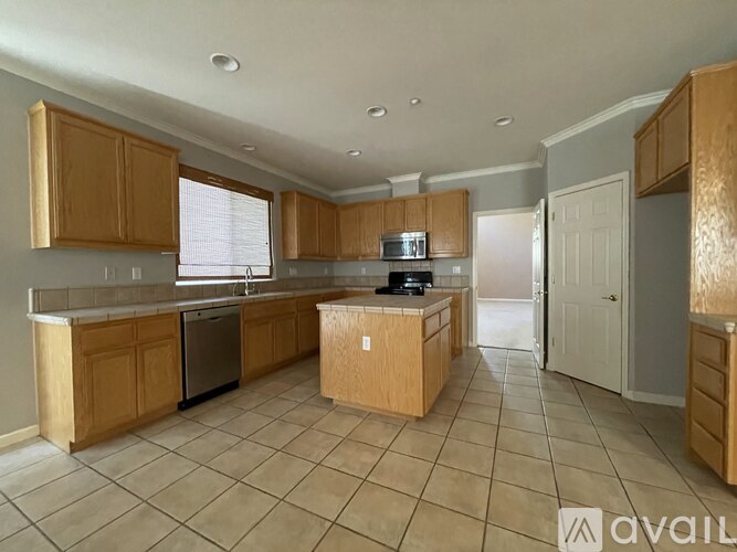 A kitchen with wooden cabinets and a tiled floor.