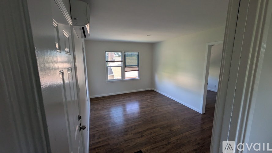 A room with wooden floors and a window letting in light.