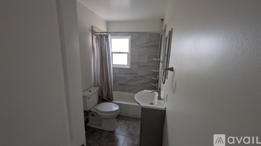 A bathroom with a toilet, sink, and shower.