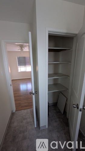 A room with a white door and a fan on the wall.