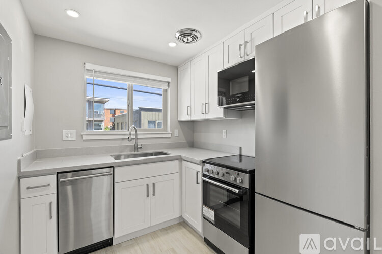 A modern kitchen with stainless steel appliances and white cabinets.