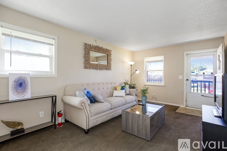 A living room with a white couch and a mirror on the wall.