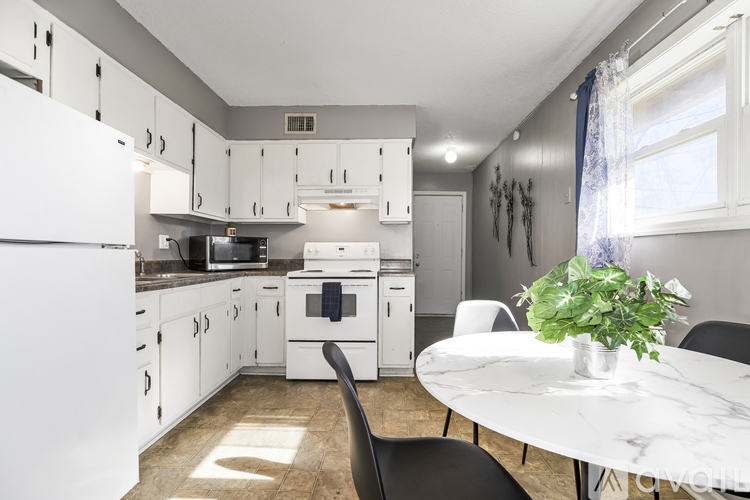 A kitchen with white cabinets and a white refrigerator.