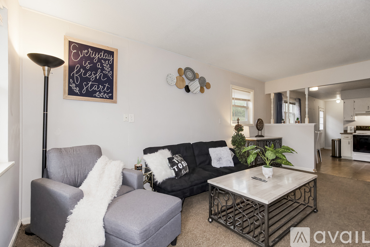 A living room with a grey couch, a grey armchair, and a coffee table.