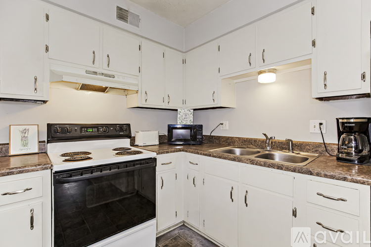 A kitchen with white cabinets and a black oven.