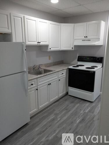 A kitchen with white appliances and cabinets.