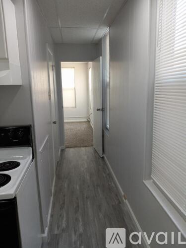A narrow hallway with a washer and dryer on the left and a door at the end.