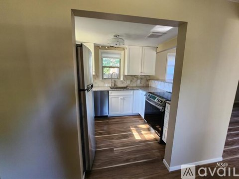 A kitchen with white cabinets and a black stove top oven.