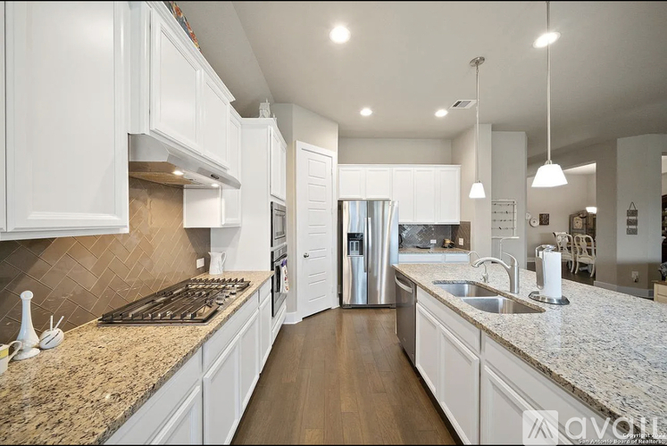 A kitchen with granite countertops and white cabinets.