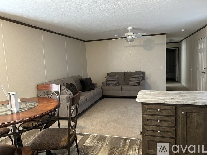A living room with a couch, chairs, and a dining table.