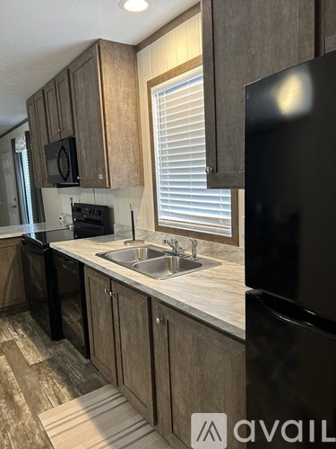 A kitchen with wooden cabinets and black appliances.