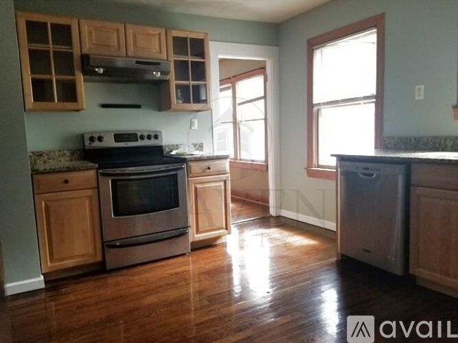 A kitchen with wooden cabinets and a stainless steel dishwasher.