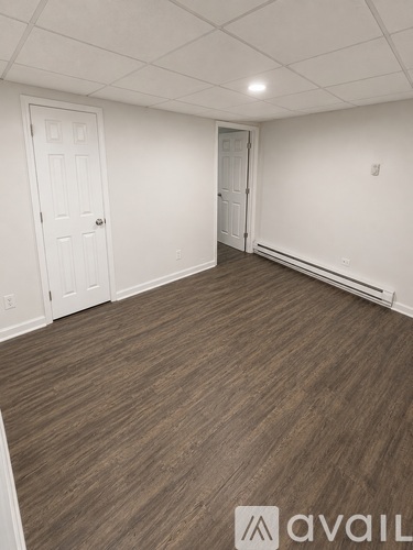 A room with wooden flooring and two doors.