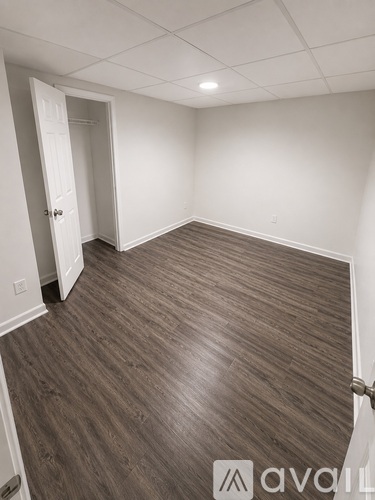 A room with wooden flooring and a white door.