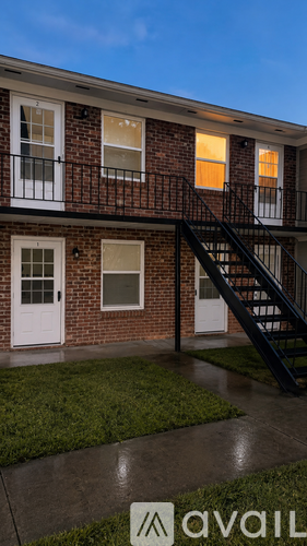 A brick building with a black staircase leading to the second floor.