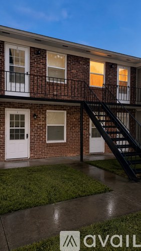 A brick building with a black staircase leading to the second floor.