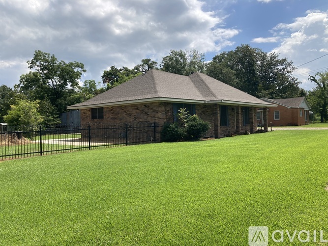 A house with a black fence and a green lawn.