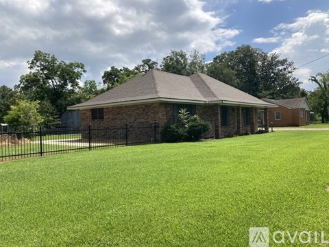 A house with a black fence and a green lawn.