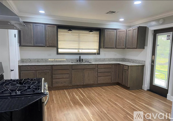 A kitchen with wooden cabinets and a black stove top.