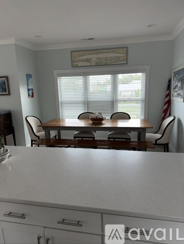 A dining room with a wooden table and chairs.