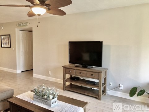 A living room with a television and a fan.