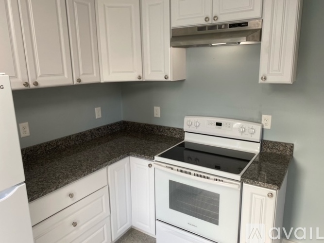 A kitchen with white appliances and cabinets.