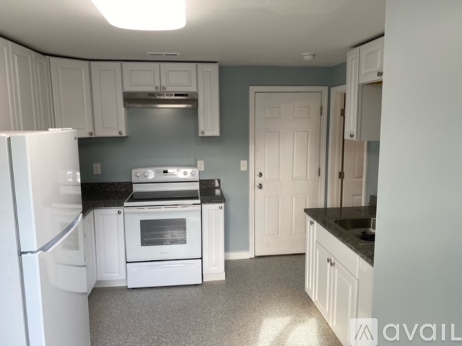 A kitchen with white appliances and cabinets.