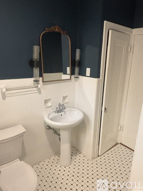 A white sink in a bathroom with a mirror above it.