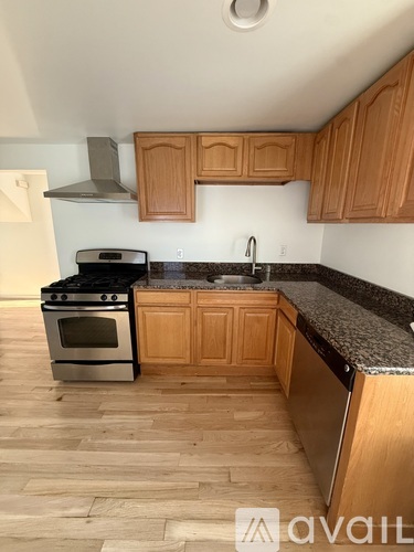 A kitchen with wooden cabinets and a black granite countertop.