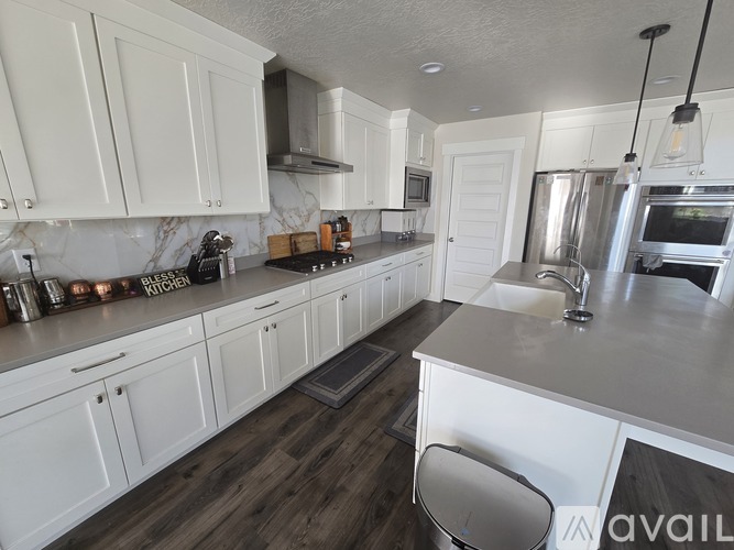 A kitchen with white cabinets and a wooden floor.