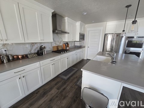 A kitchen with white cabinets and a wooden floor.