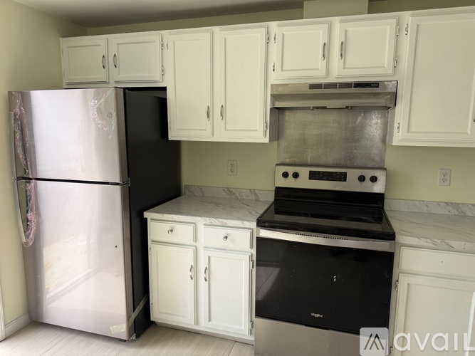 A kitchen with white cabinets and a black stove top oven.