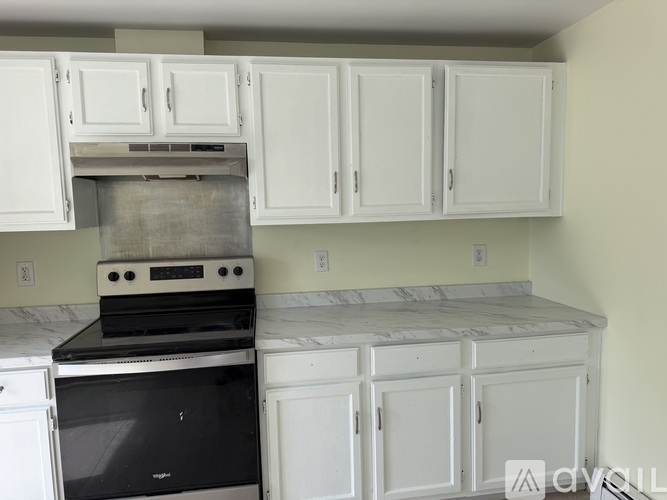 A kitchen with white cabinets and a black stove top oven.