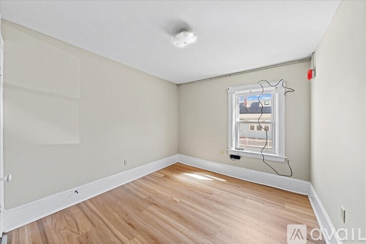 A room with a window and wooden flooring is available for rent.