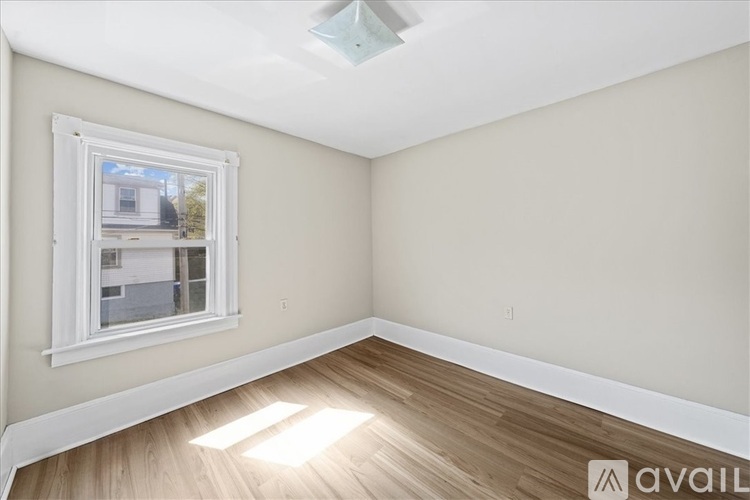 A room with a window and wooden flooring.