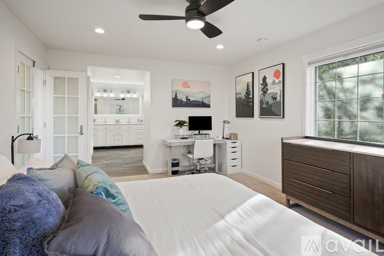 A bedroom with a large bed and a ceiling fan.
