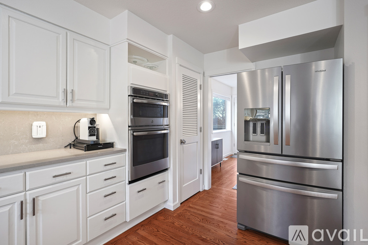 A kitchen with white cabinets and stainless steel appliances.