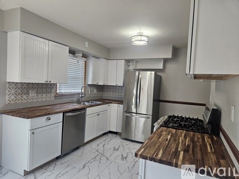 A kitchen with a wooden counter top and stainless steel appliances.
