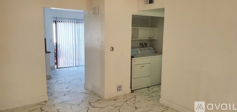A kitchen area with a fridge, cabinets and a microwave.