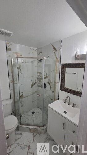A bathroom with a toilet, sink, and shower.