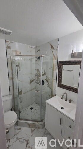 A bathroom with a toilet, sink, and shower.