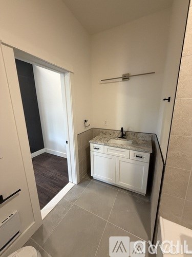 A bathroom with a sink, toilet, and a window.