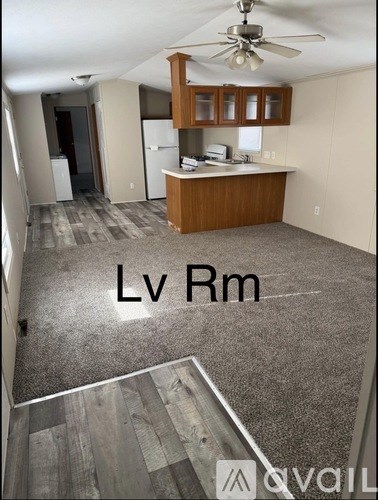 A living room with a kitchen area in the background.