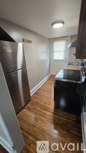 A kitchen with a stainless steel refrigerator and black stove.