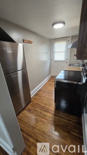 A kitchen with a stainless steel refrigerator and black stove.