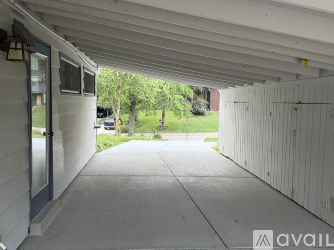 A covered walkway leads to a grassy area.